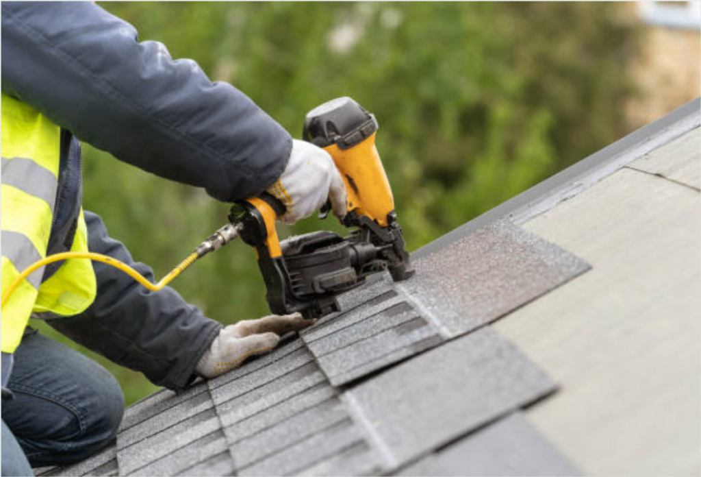 Man on a roof nailing shingles