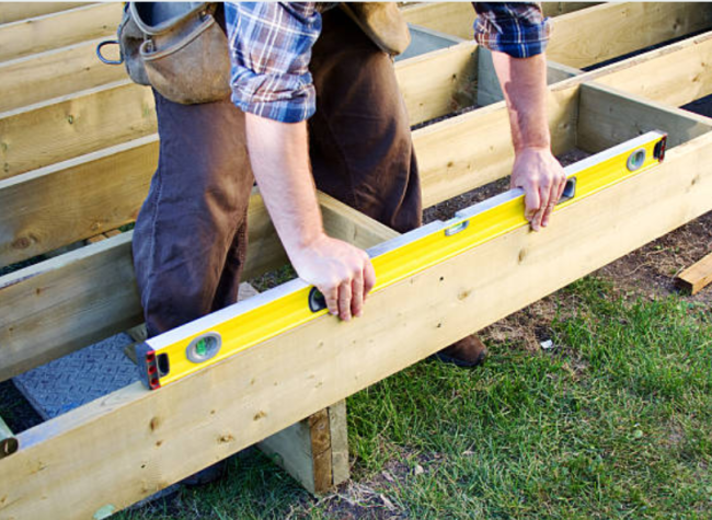 Man installing a deck making sure it's level.